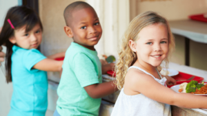 Three children quequing for school food