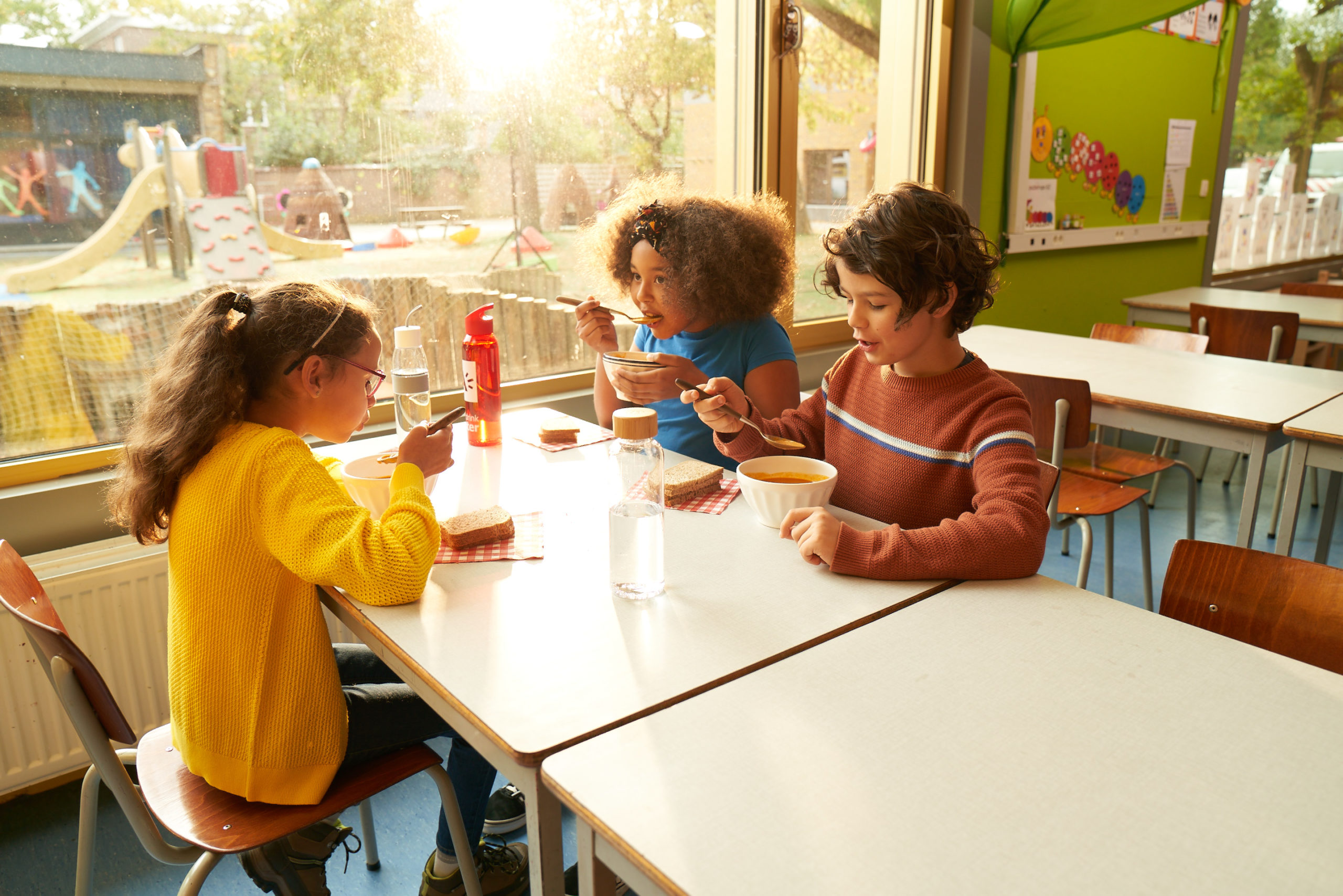 Photo of three children eating by Jakke Matthys